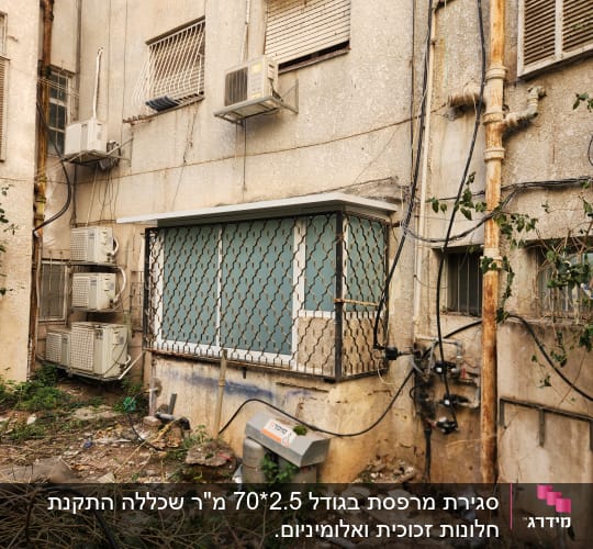 חלון עם סורגים מאלומיניום על קיר בניין ישן